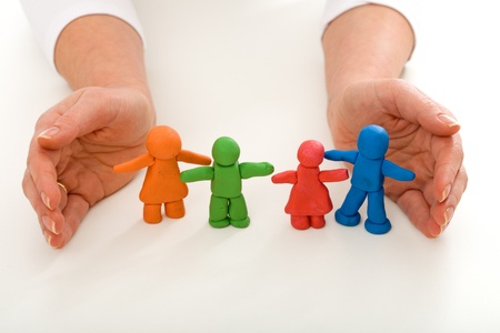 Woman hands protecting colorful clay people - happy family conceptの写真素材
