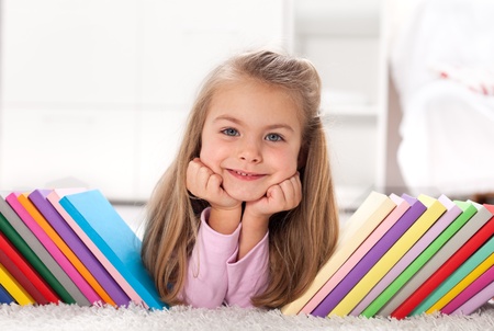 Little girl discovering the colorful world of books and knowledgeの写真素材