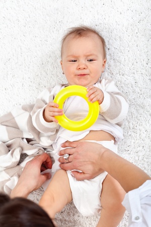 Woman changing diapers on an impatient baby girl - top viewの写真素材