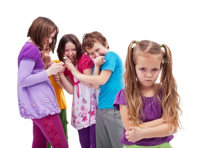 Group of kids bullying and mocking their colleague - an upset little girlの写真素材