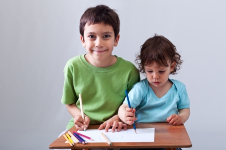 Kids drawing together - preschool boy helping his toddler brotherの写真素材