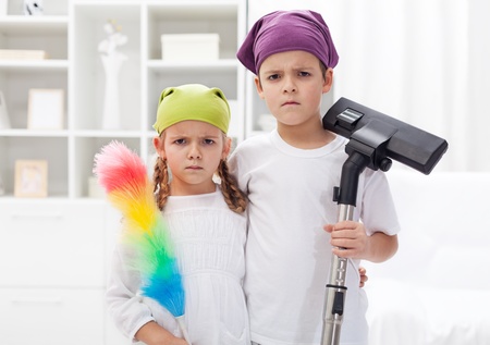 Why do we have to clean our room - upset kids with cleaning utensilsの写真素材
