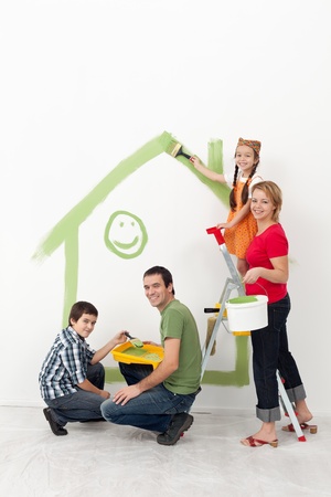 Family with kids redecorating their home - smiling with painting utensils