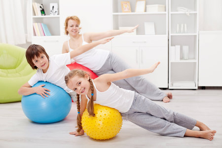 Kids exercising with their mother using large gymnastic ballsの写真素材
