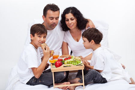 Healthy breakfast in bed - family eating fruits and frehs bakery productsの写真素材