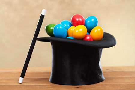 The magic of easter - colorful eggs in magician hats on golden backgroundの写真素材
