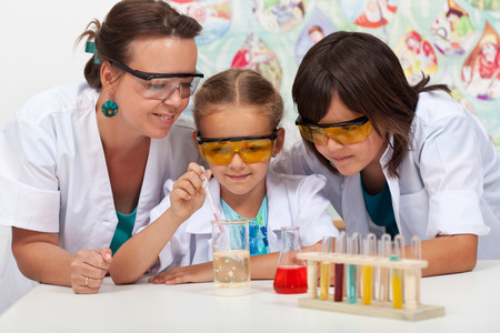 Kids in chemistry class with their teacher - doing a simple experimentの写真素材
