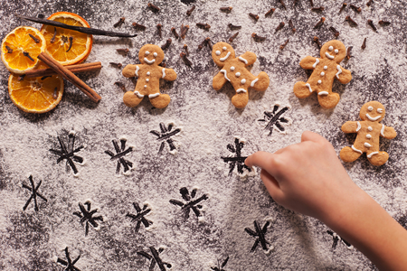 Child hand playing and drawing stars in the flour prepared for the christmas cookies, shallow depthの写真素材