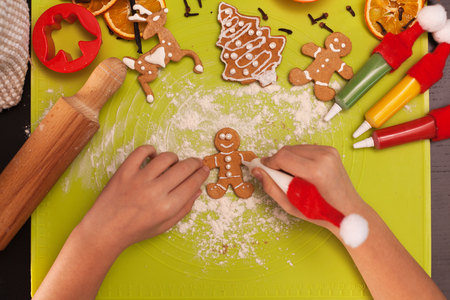 Child hands making gingerbread cookie people on the table - top view, closeupの写真素材