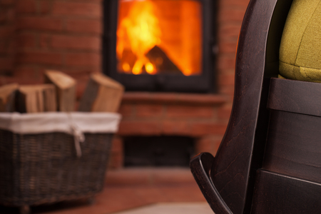 Detail of fireplace and rocking chair - cozy place at home for relaxingの写真素材