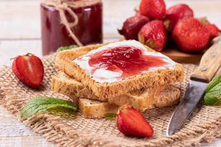 Delicious strawberry jam on toast bread - summer fruit preserve. Homemade sweets.の写真素材