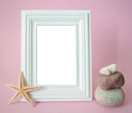 Blank white photo frame for text with balanced stones and yellow starfish on pink background tamplateの写真素材