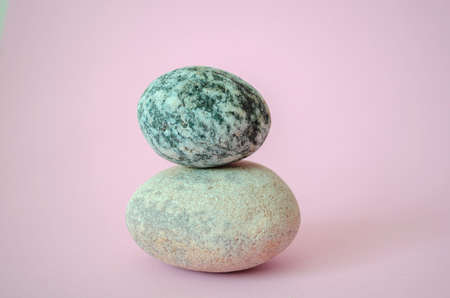 Elegant balanced stones in the center of a beauty pink backgroundの写真素材
