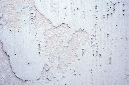 Close up grunge wall with white cracked plaster and rough texture. Perfect for backgrounds, building...