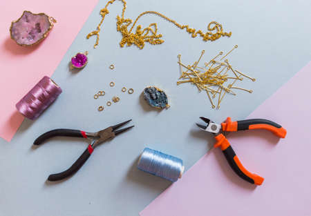 Jewelry making and beading process. Findings, pendants, geode and pliers. Making handmade jewelry. Accessories for needlework. Handmade accessories. Top view. Selective focus.の写真素材