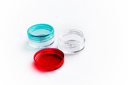 Empty small plastic or glass jar for beauty cream on white