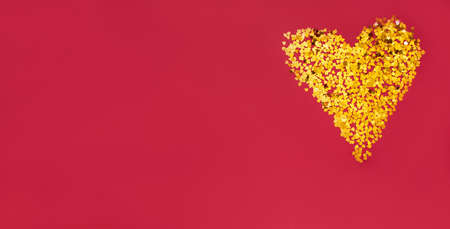 Gold heart with sparkles on red background with place for text. Valentines Day, International Womens Day.の写真素材