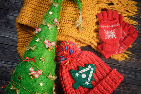 red hat and gloves, yellow scarf and Christmas ornaments on the wooden background!