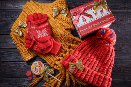 red hat and gloves, yellow scarf and Christmas ornaments on the wooden background!の写真素材