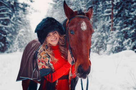 portrait of a beautiful girl and a handsome stallion, a horse in the winter on the nature, styleの写真素材