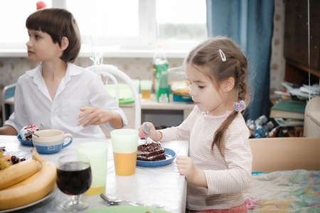 brother and sister sitting at home cakeの写真素材