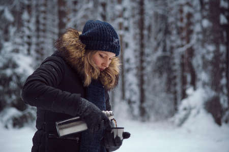 walks outdoors: girl drink hot tea from a thermos