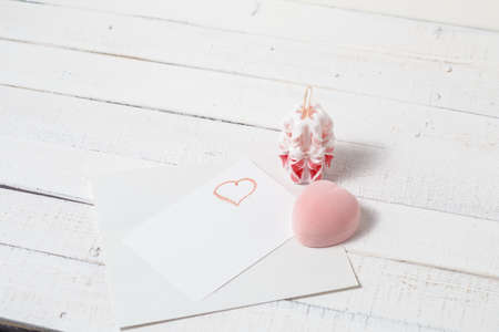 St. Valentine's Day: the offer on a romantic appointment. Two carved candles, pink box and note. Love.の写真素材