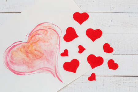 St. Valentine's Day: contrast of red and white color. Symbol of pure love. Red heart from felt. Creativity by the hands.の写真素材