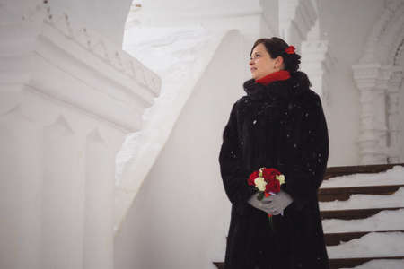 portrait of the beautiful girl, bride in the winter during snowfallの写真素材