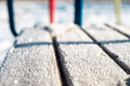 winter background: frozen snowflakes close-up on a sunny day on a tree swing,の写真素材