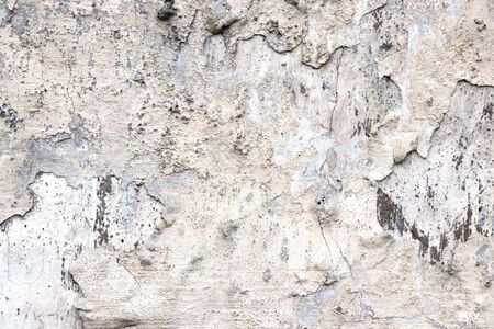 Grey old wall with paint peeling off texture in grey and yellow spots. Background for design.の写真素材
