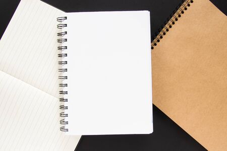 Notes with white and craft papers on a black background. Space for your text. Education concept.の写真素材