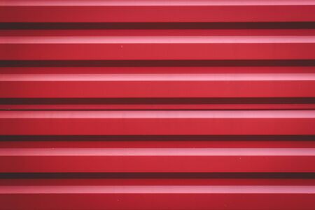 Red corrugated metal panel texture. Place for your design. Roofing material and building finishing.の写真素材