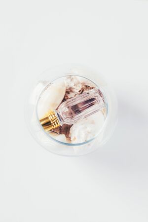 A bottle of perfume into glass form and shells. Isolated.の写真素材