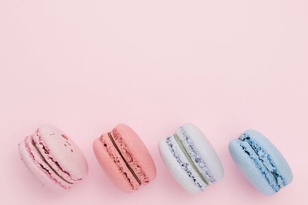 Beautiful macaroons on the pastel pink background. Horizontal color image. Place for your text or design.の写真素材