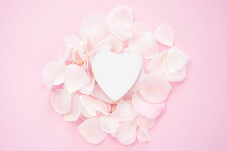 Decorative white heart with flower petals on a pink background. Flat lay. Pink image.の写真素材