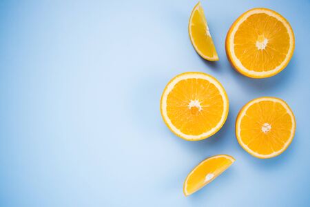 Oranges pieces of citrus on a blue background. Flat lay. Place for text. Copy space.の写真素材