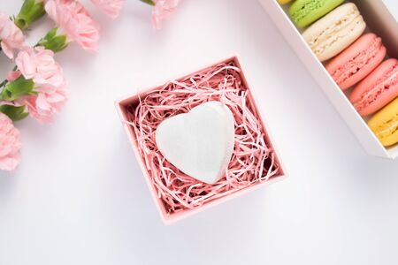 Carnation flowers, wooden decorative heart and colorful macaroons. Isolated.