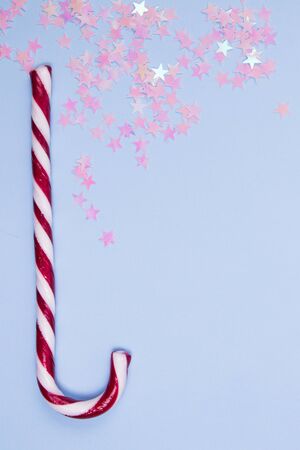 Candy cane and glitter stars on a pastel blue background.の写真素材