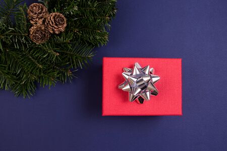 Red gift box and Christmas tree wreath on a blue background. Holidays concept.の写真素材