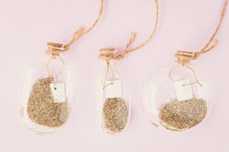 Place for text. Magic background. Decor, bottles, glitter, pink, gold. Three decorative bottles with gold glitter. Spring concept.の写真素材