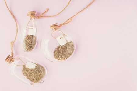 Decor, bottles, glitter, pink, gold. Three decorative bottles with gold glitter. Light pink background. Spring concept.の写真素材