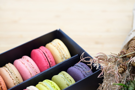 Sweet and colorful macaroons cookies in the black box on wooden background with blank space,selective focus, Dessert.の写真素材
