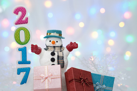 2017 Happy New Year, Santa Claus and gift box on ice with bokeh background.