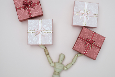 Wooden dummy carrying a wooden box on pink background with copy space for write and valentine and...
