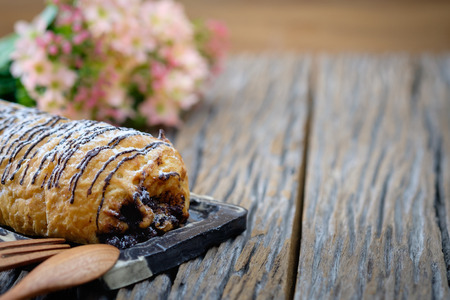 Homemade Chocolate Croissant Pastry with Powdered Sugar on wooden background.の写真素材