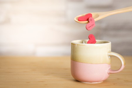 Pouring the heart shape put into the glass ceramic with the spoon on wooden background, Space to write. Valentines concept, Vintage tone, AF point selection.の写真素材