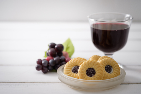 Blueberry Biscuits put on a ceramic plate and bunch of purple grapes placed close together on white wooden background, Selective focus.の写真素材