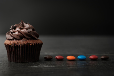 Chocolate cupcake with colorful candy in Dark lighting, AF point selection.の写真素材