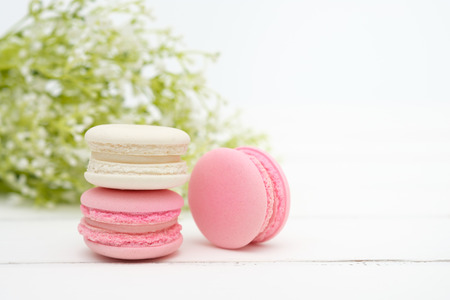 Macaroons and flowers on the white wooden background.の写真素材